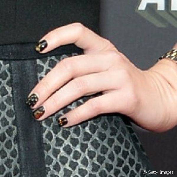 Alexa Vega apostou na nail art de po? dourado sobre esmalte preto para comparecer ao MTV Movie Awards 2013, mas criou uma quantidade de bolinhas diferente para cada uma das unhas